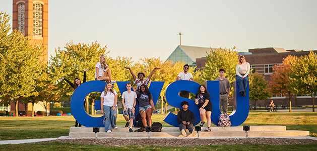 Students posing around a 'GVSU' art installation